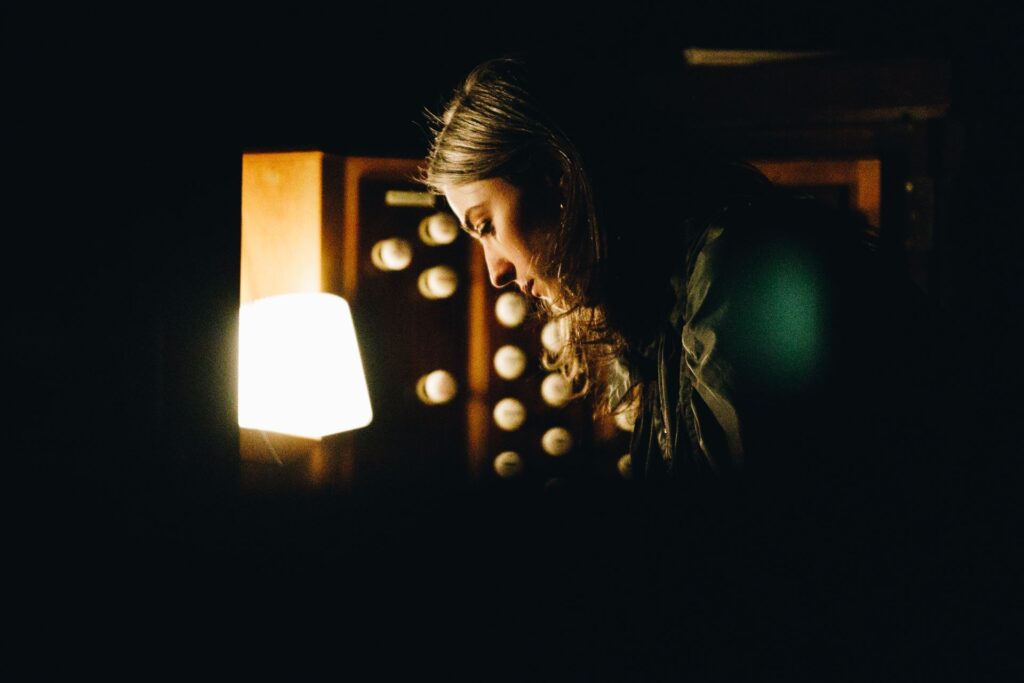 A woman leaning over an organ.